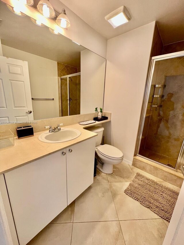 bathroom featuring vanity, toilet, and a shower with shower door