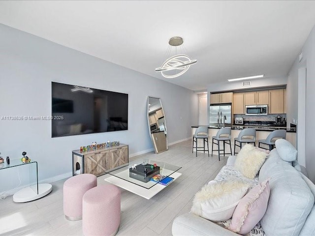 living area with light wood-style flooring and baseboards