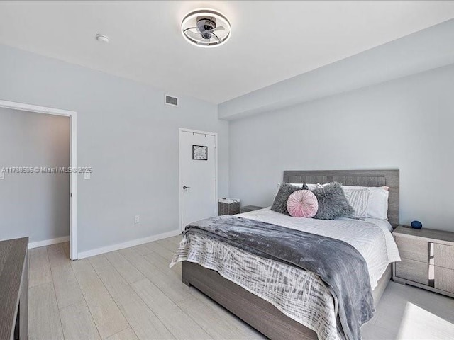 bedroom with visible vents, baseboards, and wood finished floors