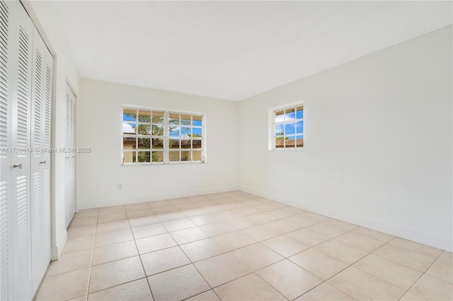 unfurnished bedroom with light tile patterned floors and a closet