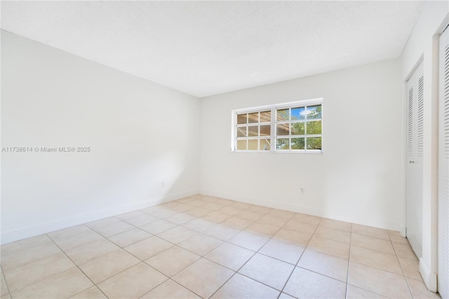 tiled spare room with a textured ceiling