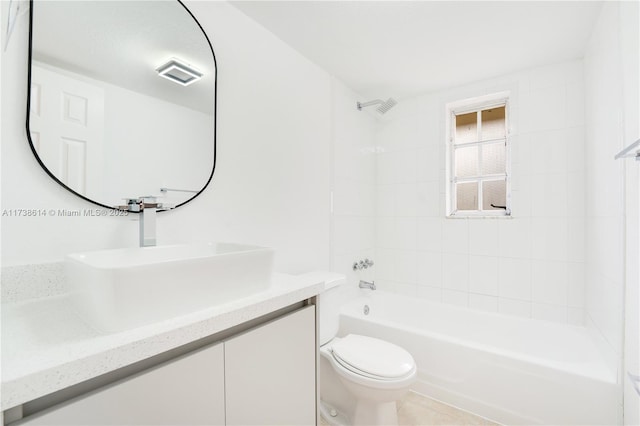 full bathroom featuring tiled shower / bath, vanity, and toilet