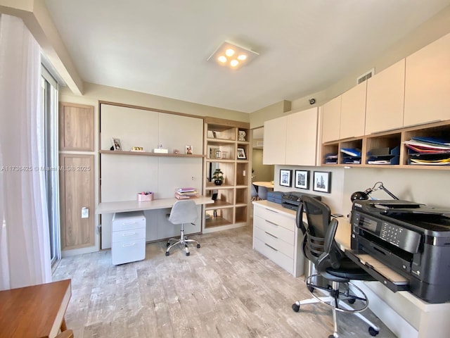 home office featuring built in desk and light hardwood / wood-style flooring