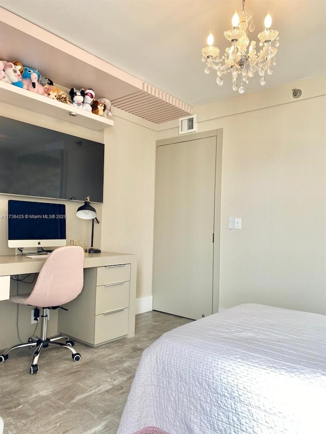 bedroom featuring light hardwood / wood-style flooring and a chandelier