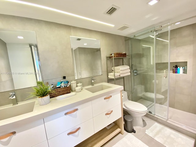 bathroom with vanity, tile patterned flooring, a shower with door, and toilet