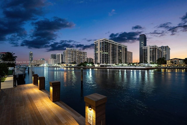 view of dock featuring a water view and a view of city