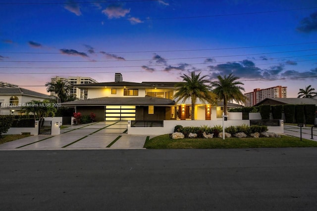 view of front of home featuring concrete driveway and fence