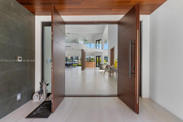 hallway featuring wooden ceiling and a towering ceiling