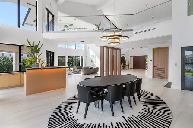 dining space with a towering ceiling and an inviting chandelier