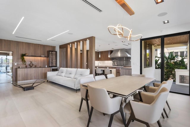 dining room with wood walls and a notable chandelier