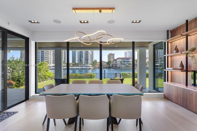 dining room featuring a view of city, a water view, a wealth of natural light, and a notable chandelier