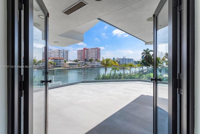 balcony featuring a view of city, a water view, and visible vents