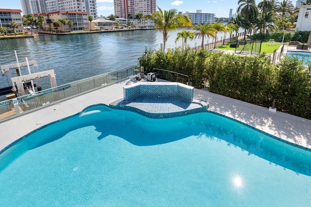 view of swimming pool with a water view, a fenced in pool, fence, and a city view