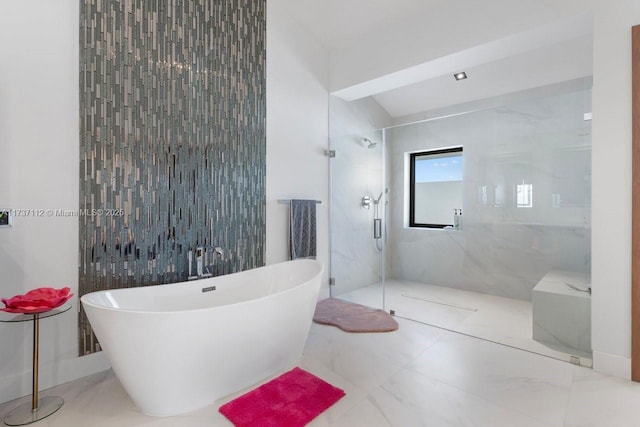 full bath with marble finish floor, a freestanding bath, tile walls, and a marble finish shower