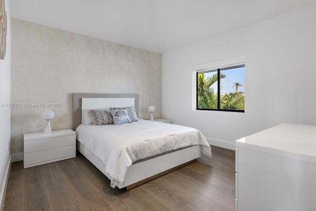 bedroom featuring baseboards and dark wood-type flooring