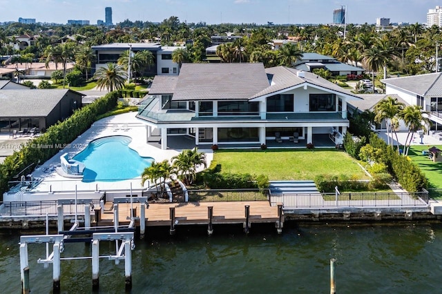 rear view of property featuring a water view, boat lift, a community pool, and a patio