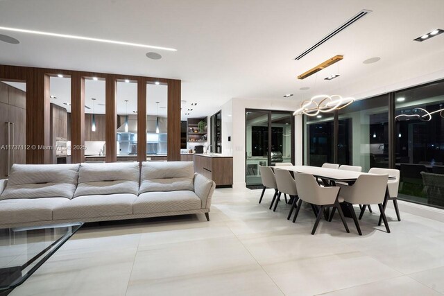 living area with light tile patterned floors, visible vents, and a chandelier