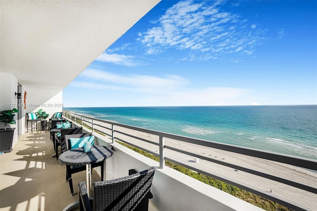 balcony featuring a water view and a beach view