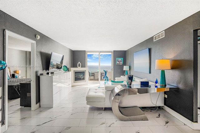 living room featuring expansive windows and a textured ceiling