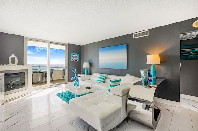 living room with expansive windows and a textured ceiling