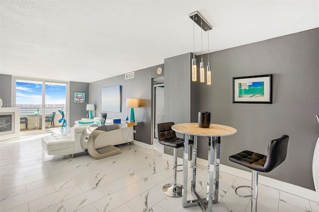 dining room with a wall of windows and a textured ceiling