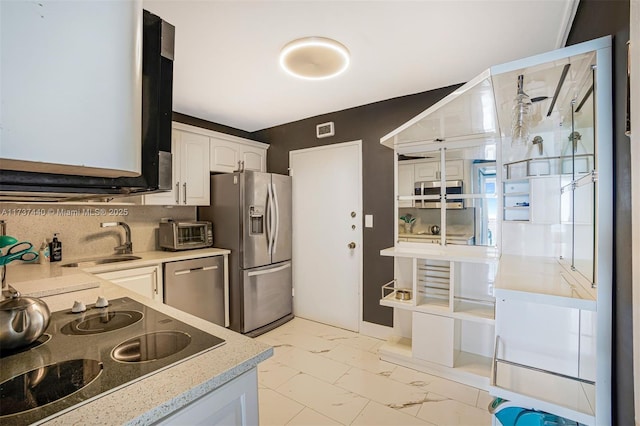 kitchen featuring tasteful backsplash, sink, white cabinets, and appliances with stainless steel finishes