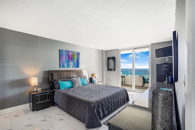 bedroom with access to outside, floor to ceiling windows, and a textured ceiling