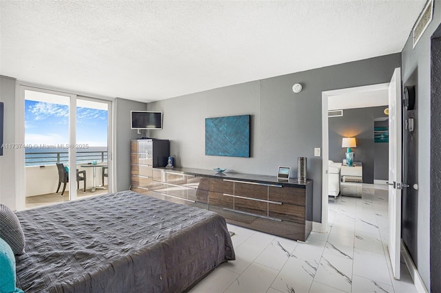 bedroom featuring access to exterior and a textured ceiling