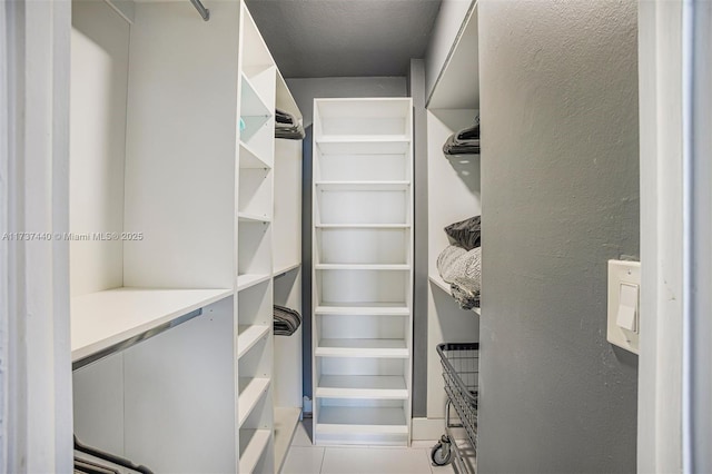 walk in closet with light tile patterned floors