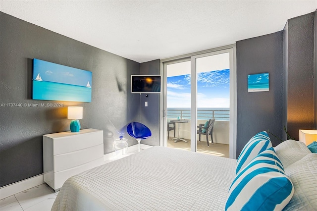 bedroom with a wall of windows, access to exterior, and a textured ceiling