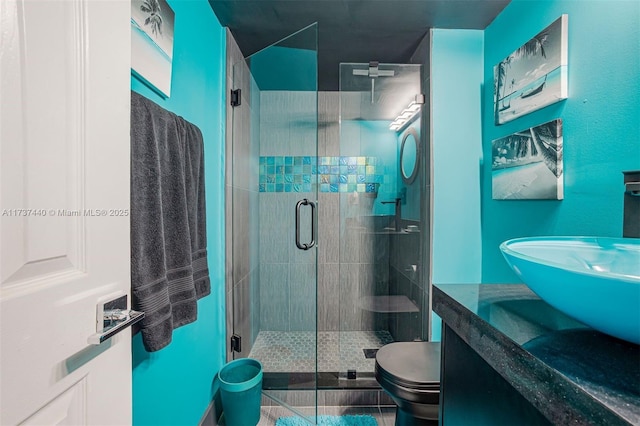 bathroom with vanity, a shower with shower door, and toilet