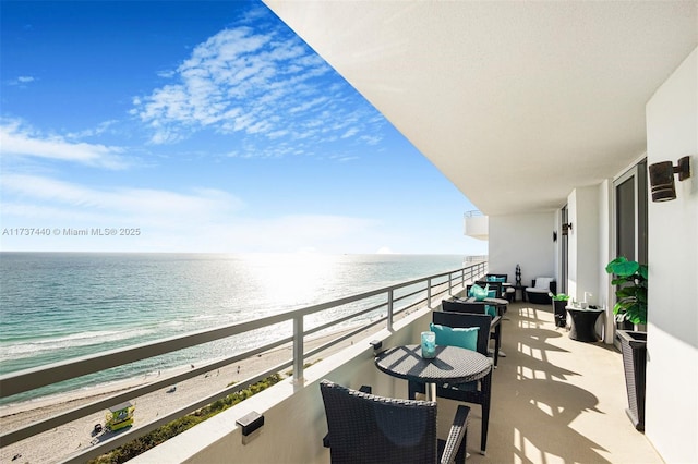 balcony with a water view and a beach view