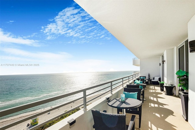 balcony featuring a water view and a beach view