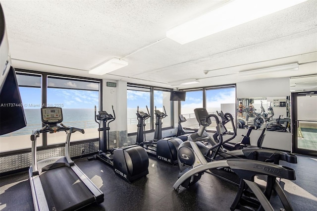 gym with expansive windows and a textured ceiling