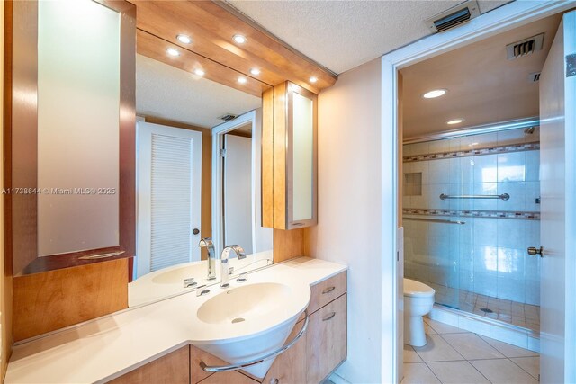 bathroom featuring tile patterned flooring, an enclosed shower, vanity, a textured ceiling, and toilet