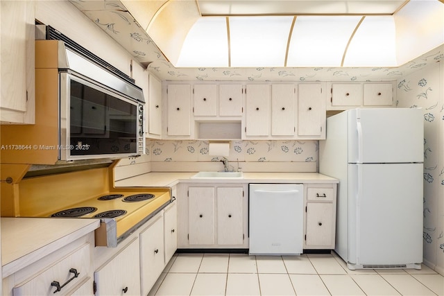 kitchen featuring sink, white appliances, white cabinets, and light tile patterned flooring