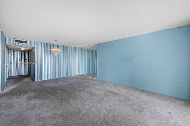 carpeted spare room with a textured ceiling