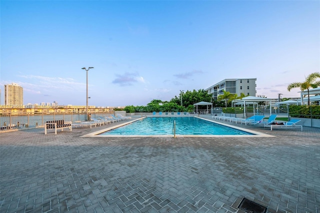 view of swimming pool featuring a gazebo, a patio, and a water view