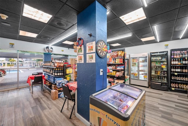 game room with hardwood / wood-style floors and a drop ceiling