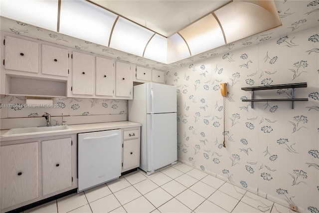 kitchen featuring sink, light tile patterned floors, and white appliances