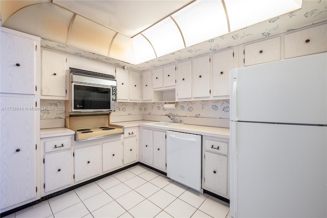 kitchen featuring sink, white cabinets, and white appliances