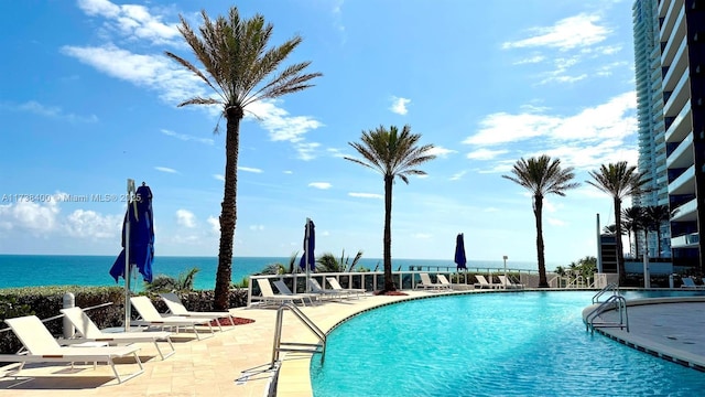 view of swimming pool with a water view and a patio