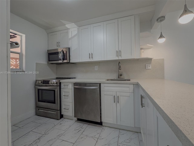 kitchen with sink, decorative light fixtures, appliances with stainless steel finishes, decorative backsplash, and white cabinets