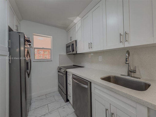 kitchen featuring tasteful backsplash, white cabinetry, appliances with stainless steel finishes, and sink