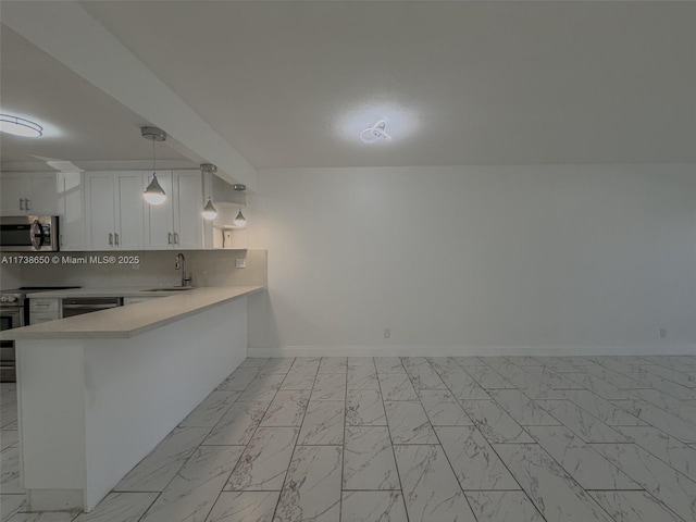 kitchen with sink, tasteful backsplash, kitchen peninsula, pendant lighting, and white cabinets