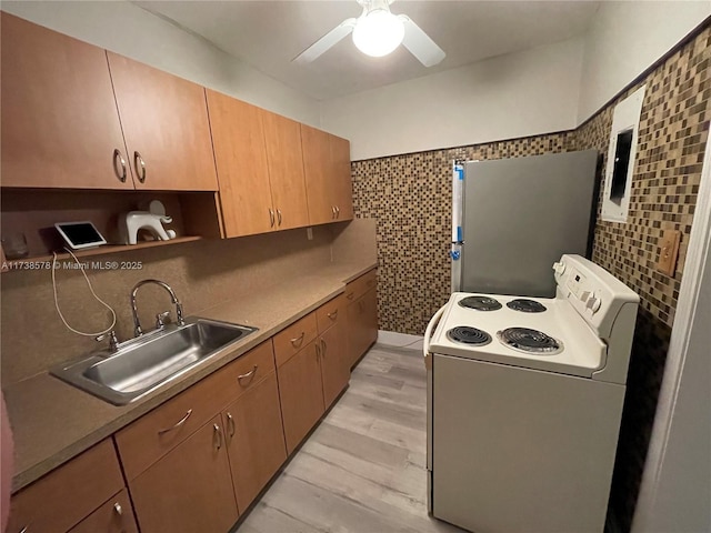 kitchen featuring sink, white appliances, tile walls, light wood-type flooring, and ceiling fan