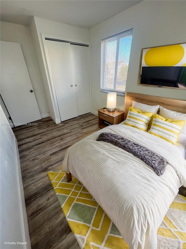 bedroom with dark hardwood / wood-style floors and a closet