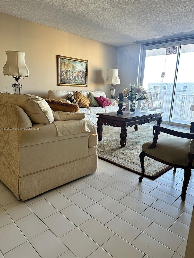 tiled living room featuring floor to ceiling windows and a textured ceiling