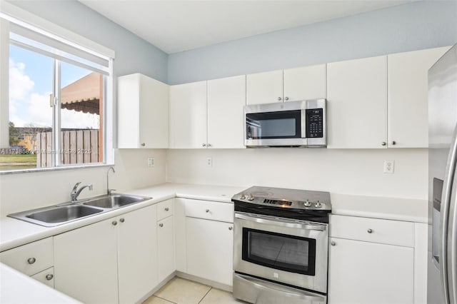 kitchen featuring white cabinetry, appliances with stainless steel finishes, sink, and light tile patterned floors