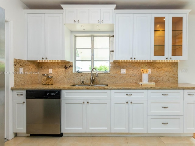 kitchen with sink, white cabinetry, tasteful backsplash, light stone counters, and dishwasher